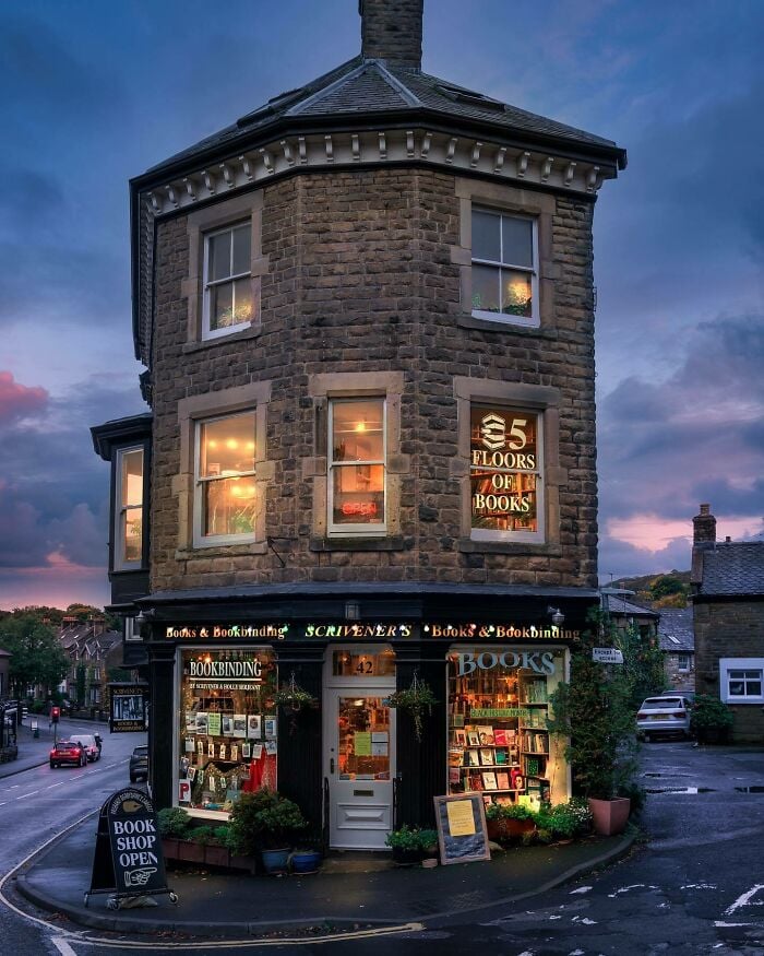 Cozy and grandiose bookstore with warm lights in a historic stone building showcasing magical library charm.