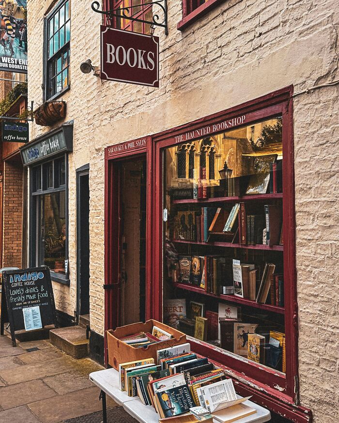 Cozy and grandiose bookstore with books displayed outside, featuring a charming facade and warm inviting atmosphere.